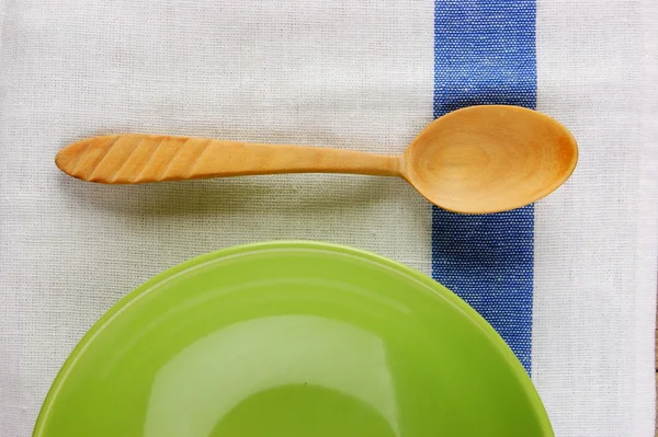 wooden spoon with a plate on the table cloth on an old wooden ta