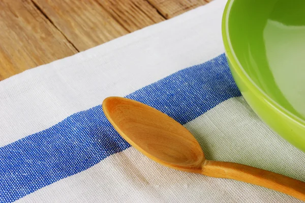 Wooden spoon with a plate on the table cloth on an old wooden table