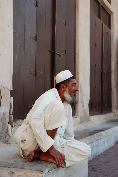 Old man sitting on the stone steps of the old city of Bar Dubai