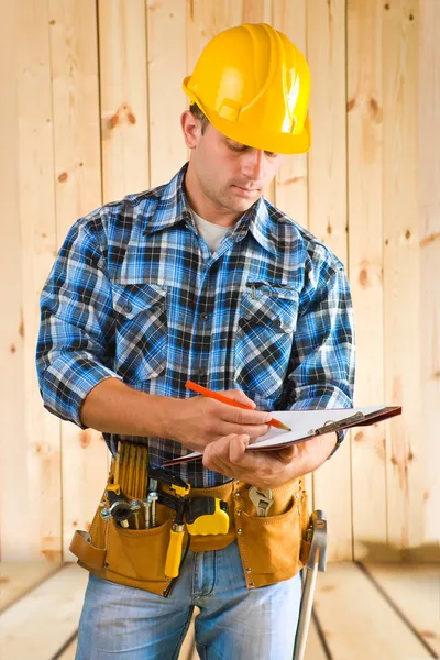 Arbeiter schreiben auf Klemmbrett — Stockfoto