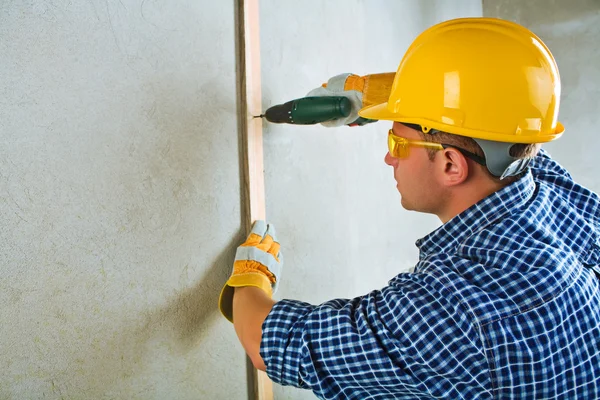 Ein Auftragnehmer, der mit elektrischen Schraubendreher arbeitet — Stockfoto