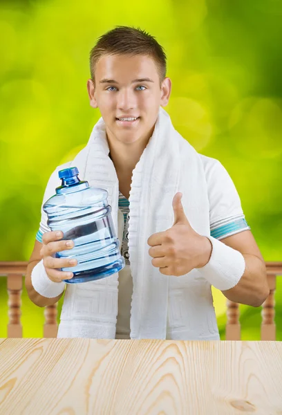 Un mec tenant une grosse bouteille d'eau — Photo