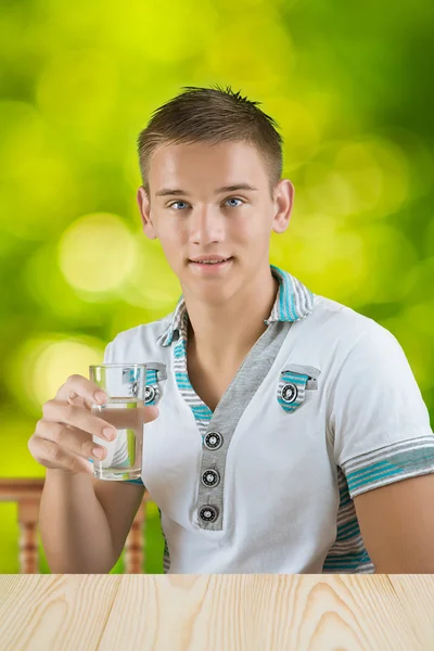 En kille som håller glas vatten — Stockfoto