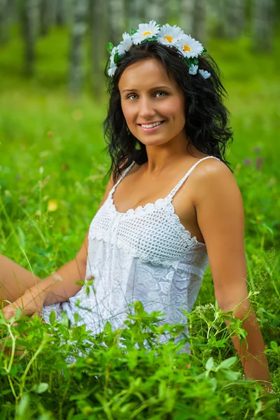 Brunette zittend op het gras — Stockfoto