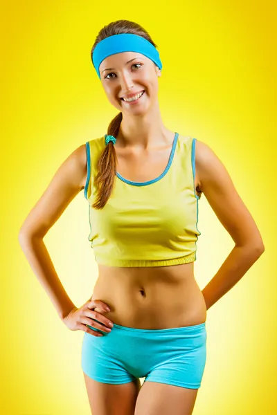 Una ragazza sportiva su sfondo giallo — Foto Stock