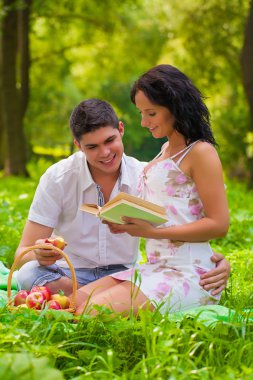 Parkta çimlerde oturan genç çift