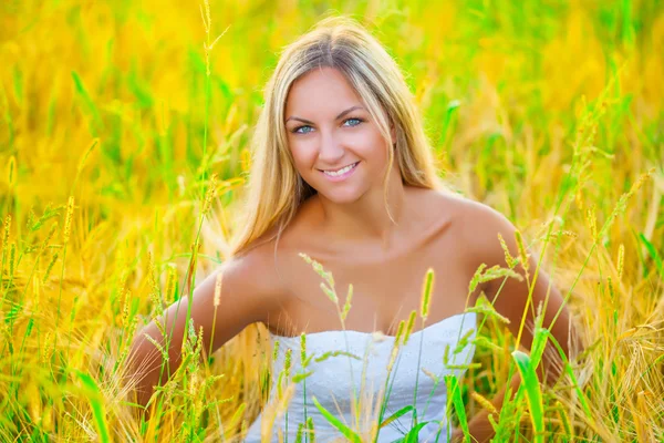 Beautiful smiling blonde on wheat field — Stock Photo, Image