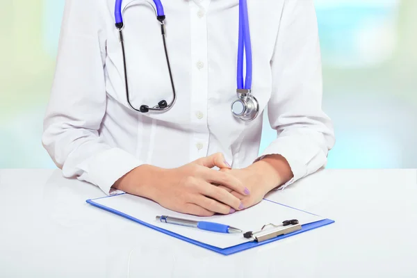 A doctor at the table with clipboard very closeup — Stock Photo, Image