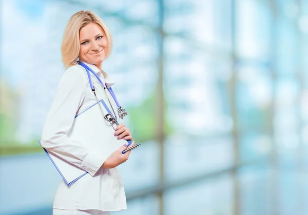 Female doctor holding clipboard in office — Stock Photo, Image
