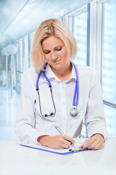 Female doctor writting with a ball point pen — Stock Photo, Image