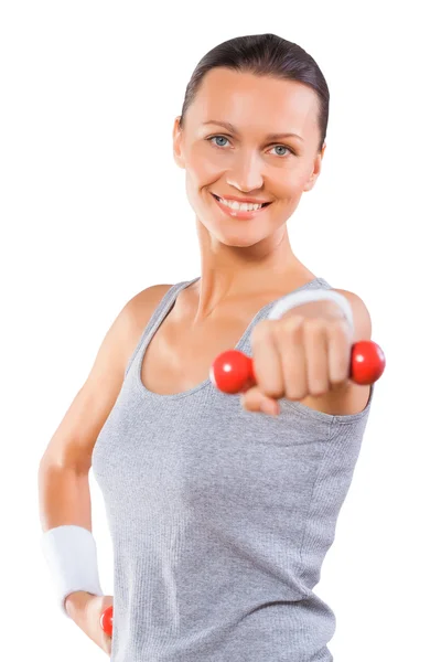 Una donna sportiva che regge manubri e sorride isolata — Foto Stock