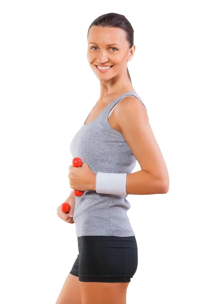 Sportswoman smiling holding small dumbbells — Stock Photo, Image