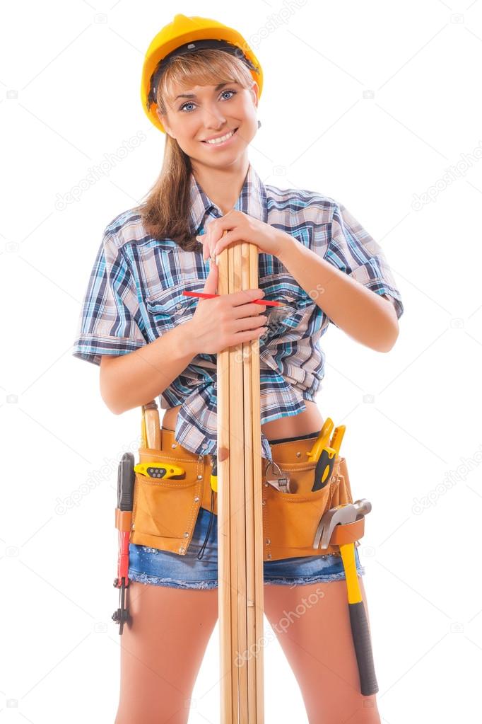 Half length portrait of happy female construction worker with wooden planks and tool belt