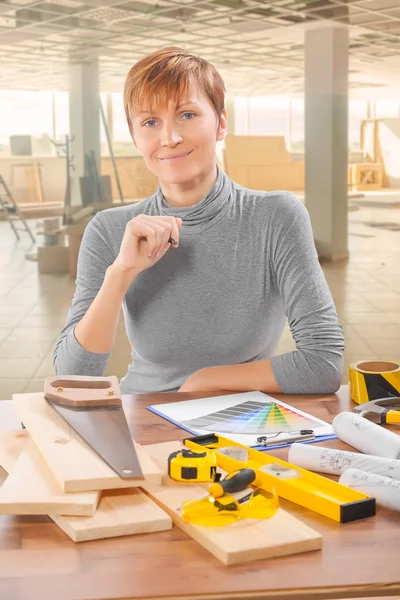 Travailleuse assise à table avec des outils — Photo