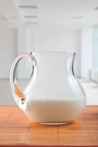 Džbánek s mlékem na stole — Stock fotografie