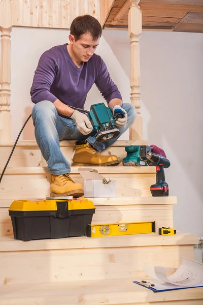 Carpinteiro sentado no degrau de escada de madeira — Fotografia de Stock