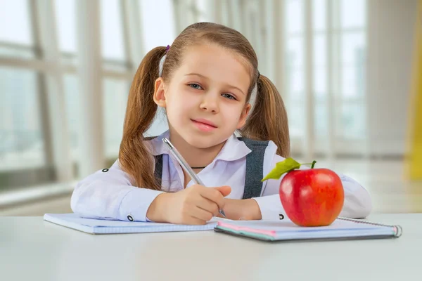 Όμορφη litle μαθήτρια κάθεται σε τραπέζι — Φωτογραφία Αρχείου