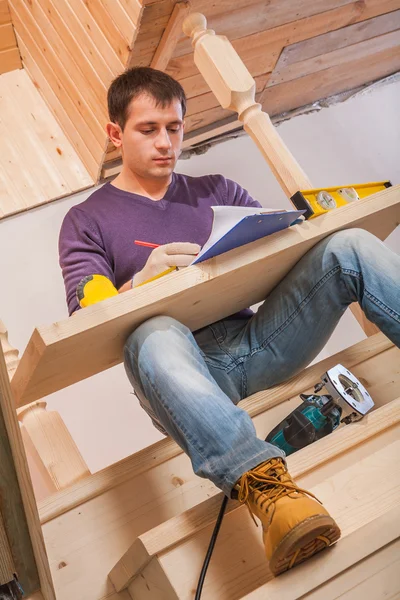 Trabajador sentado con tablero de madera — Foto de Stock