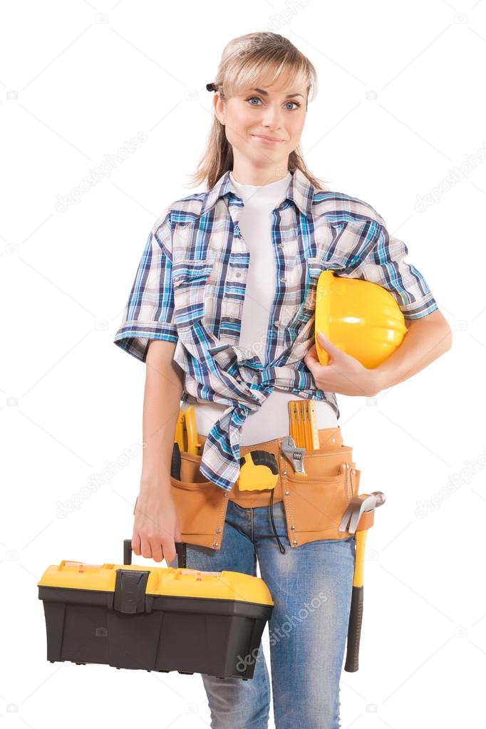 Female wearing working clothes with toolbelt holding hardhat