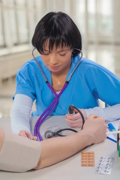 Kobieta lekarz pomiaru ciśnienia krwi — Zdjęcie stockowe