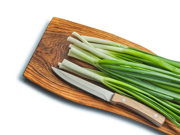 木柴碎木板上的绿色洋葱堆栈和厨房菜刀 — 图库照片
