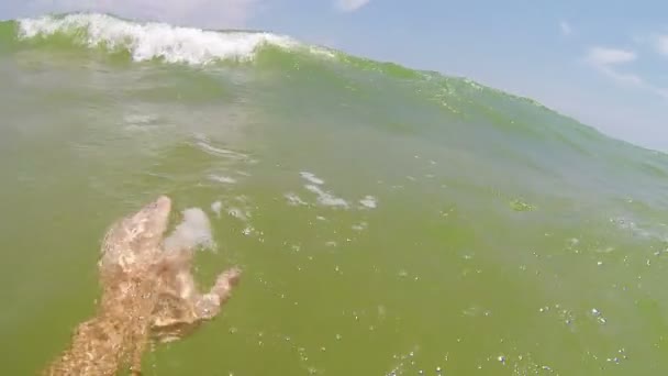 Gran ola de mar cubre a un nadador en una playa — Vídeo de stock