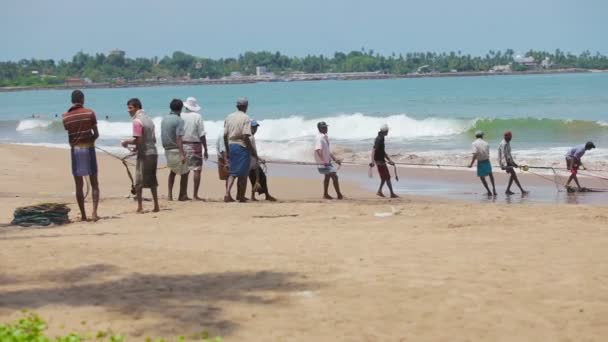 ХИККАДУВА (ШРИ-ЛАНД) - 26 апреля 2013 года в Хкадуве (Шри-Ланка) местные рыбаки вытащили из океана сети. Мужчины, собранные для совместной рыбалки — стоковое видео