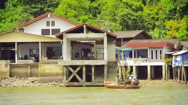 RANONG, THAILAND - NOV 11: Casa grande em pilhas e barco longo de madeira tradicional na zona off-shore em 11 de novembro de 2013 em Ranong, Tailândia . — Vídeo de Stock