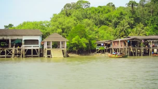 RANONG, THAILAND - NOV 11: Wooden cabins and traditional long boat in off-shore zone on Nov 11, 2013 in Ranong, Thailand. — Stock Video