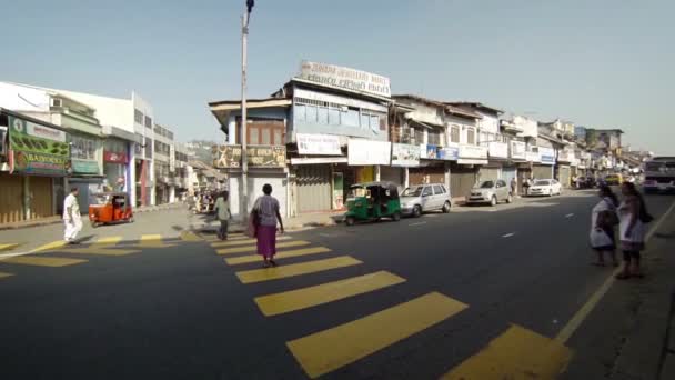 Кэнди, Шри-Ланка - 18 апреля 2013 года в Канди, Шри-Ланка, местные жители проходят большой перекрёсток на городской дороге с типичными видами транспорта . — стоковое видео
