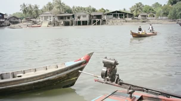 RANONG, THAILAND - 11 NOV 2013: People in traditional wooden long boat navigate in river boat traffic. Wooden boats is common transport in coastal areas. — Stock Video