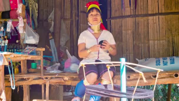 CHIAND RAI, THAILAND - 04 DEC 2013: Kayan Lahwi (Long-Necked Kayan) woman with neck rings spin yarn in hill tribe village. — Stock Video