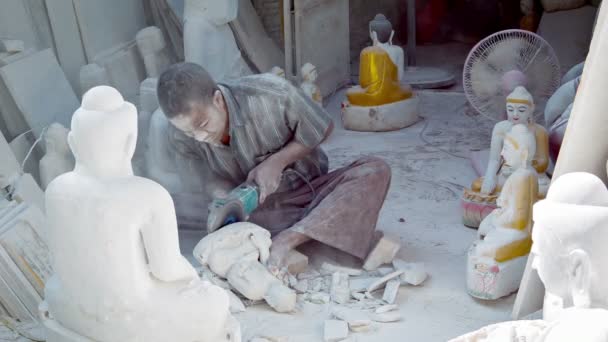 MANDALAY, MYANMAR - 13 JAN 2014: Покрытые пылью резчика по мраморному камню сделать изображение Будды в небольшой мастерской с угол-шлифовальный станок — стоковое видео