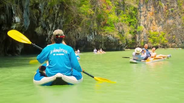 PHANG NGA, TAILANDIA - 24 FEB 2014: Pequeños barcos - kayaks se utilizan para el entretenimiento de los turistas. Inspección de antiguos acantilados de piedra caliza en el mar tropical — Vídeos de Stock