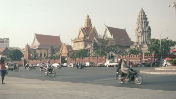 Phnom penh, Kambodża - 29 grudzień 2013: Azji transportu ruchu i pieszych na ulicy centralnej nabrzeża z wat ounalom na tle — Wideo stockowe