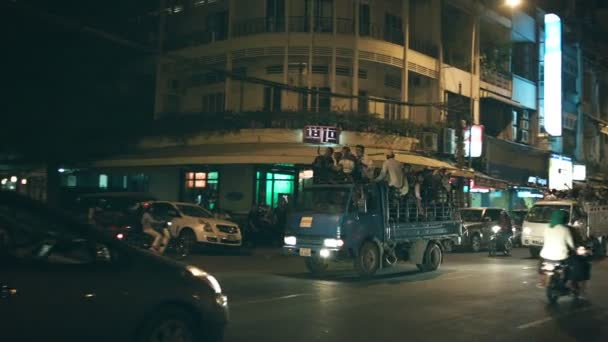 PHNOM PENH, CAMBODIA - 29 DIC 2013: Traffico notturno sulle strade cittadine. Gruppi di persone vanno per le strade sul retro dei camion — Video Stock