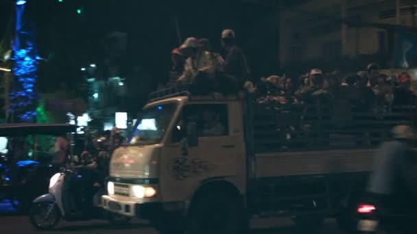 PHNOM PENH, CAMBODIA - 29 DIC 2013: Strade notturne. Gente sul retro dei camion — Video Stock