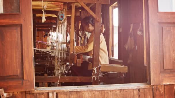 LAGO INLE, MYANMAR - CIRCA GENNAIO 2014: Vecchia fabbrica di tessitura. Una donna del posto produce tessuto su un telaio. — Video Stock
