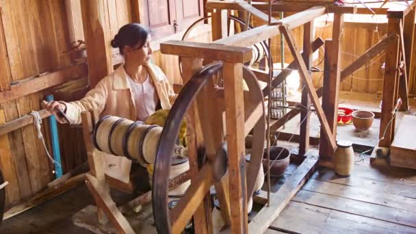 INLE LAKE, MYANMAR - CIRCA JAN 2014: Woman working with the old mechanism for the production of yarn — Stock Video