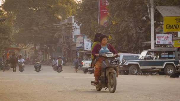 BAGAN, MYANMAR - 11 ENE 2014: Tráfico común de transporte asiático en una calle con coches, motos, bicicletas, carruajes de caballos . — Vídeos de Stock