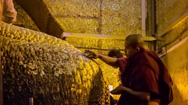MANDALAY, MYANMAR - 13 JAN 2014: People put golden leaves on Mandalay Maha Myat Muni Buddha Image in Mahamuni Buddha Temple. It is major pilgrimage site in Mandalay and Burma. — Stock Video