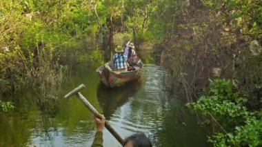 Siem reap, Kamboçya - 21 Aralık 2013: küçük tekne rowed bir kürek beetween ağaçlar ve çalılar tonle sap Gölü. Güneydoğu Asya'nın en büyük tatlı su Gölü tonle sap olduğunu.