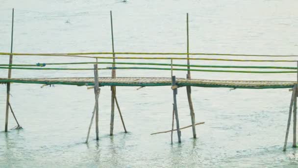 Luang prabang, laos - ca. Dez 2013: Touristen und Einheimische nutzen eine kleine Bambusbrücke über den Fluss — Stockvideo