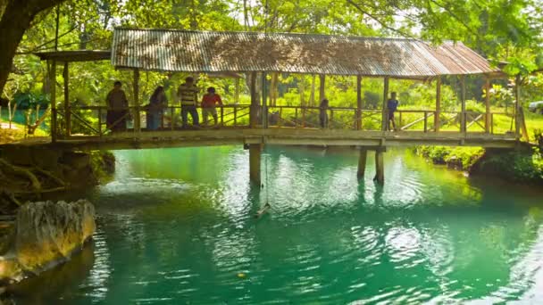 Vang vieng, laos - 15 Aralık 2013: turizm turkuaz su popüler turistik cazibe - mavi lagün yukarıda ahşap köprü. — Stok video