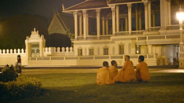 PHNOM PENH, CAMBODIA - 29 DEC 2013: Группа буддийских монахов возле королевского дворца вечером — стоковое видео