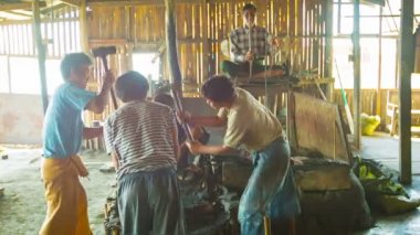INLE LAKE, MYANMAR - CIRCA JAN 2014: Blacksmiths are working together on the production of weapons in the smithy