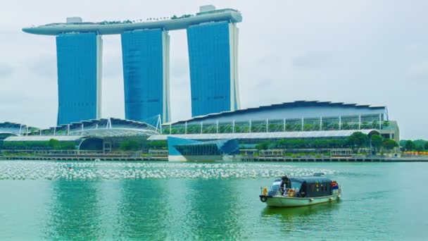 SINGAPUR - 01 ENE 2014: Barco con turistas cruzan Bahía Marina con Marina Bays Edificio de arenas sobre fondo — Vídeos de Stock