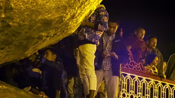 МОН-ГОСУДАРСТВО, МЯНМАР - 04 ЯН 2014: Только мужчины приклеивали маленькие кусочки золота к священной скале - пагода Кяйктиё — стоковое видео