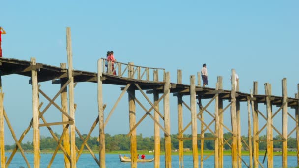 MANDALAY, MYANMAR - 13 JAN 2014: U Bein Bridge across the Taungthaman Lake. The 1.2 km  bridge was built around 1850 and is the oldest and longest teakwood bridge in the world — Stock Video