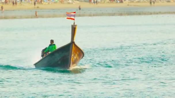 PHUKET, THAILAND - 05 OCT 2013: Traditional long tail wooden motor boat navigate in calm blue sea near the beach — Stock Video